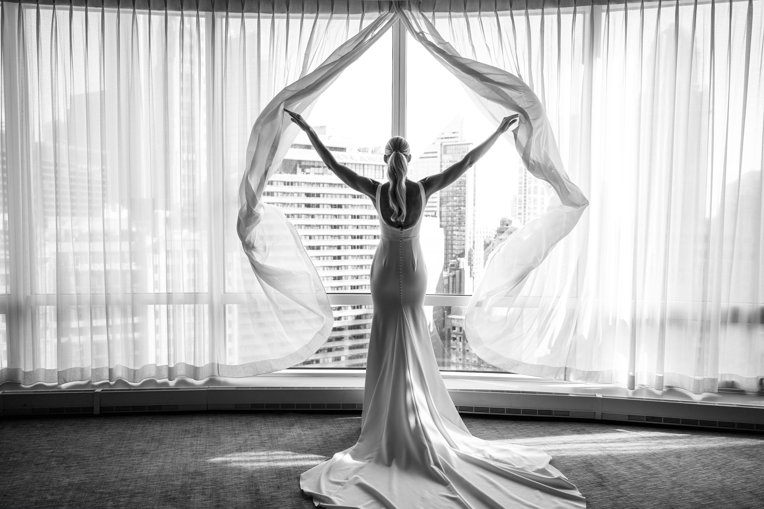 bride silhouette opening curtains in Trum International Hotel bridal suite in Chicago
