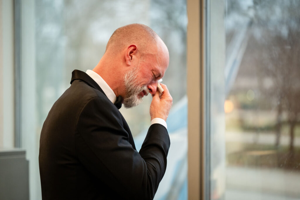 Bride’s father wiping away tears during an emotional first look at the hotel before the wedding ceremony