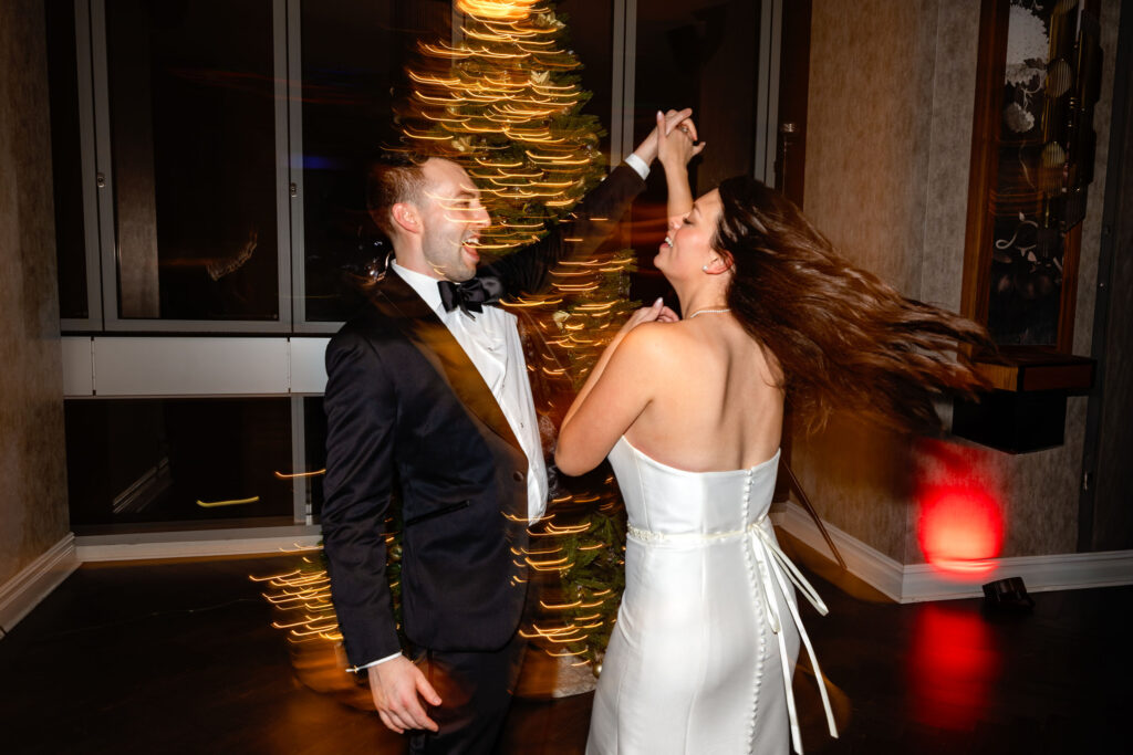 Bride and groom dancing during their wedding reception at the hotel connected to LM Studio, surrounded by warm lighting and motion blur.