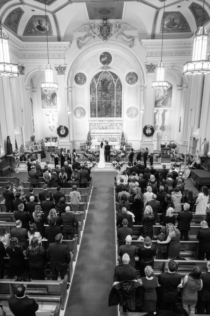 Wide view of a Catholic wedding ceremony at Assumption Catholic Church in Chicago, photographed from the choir loft