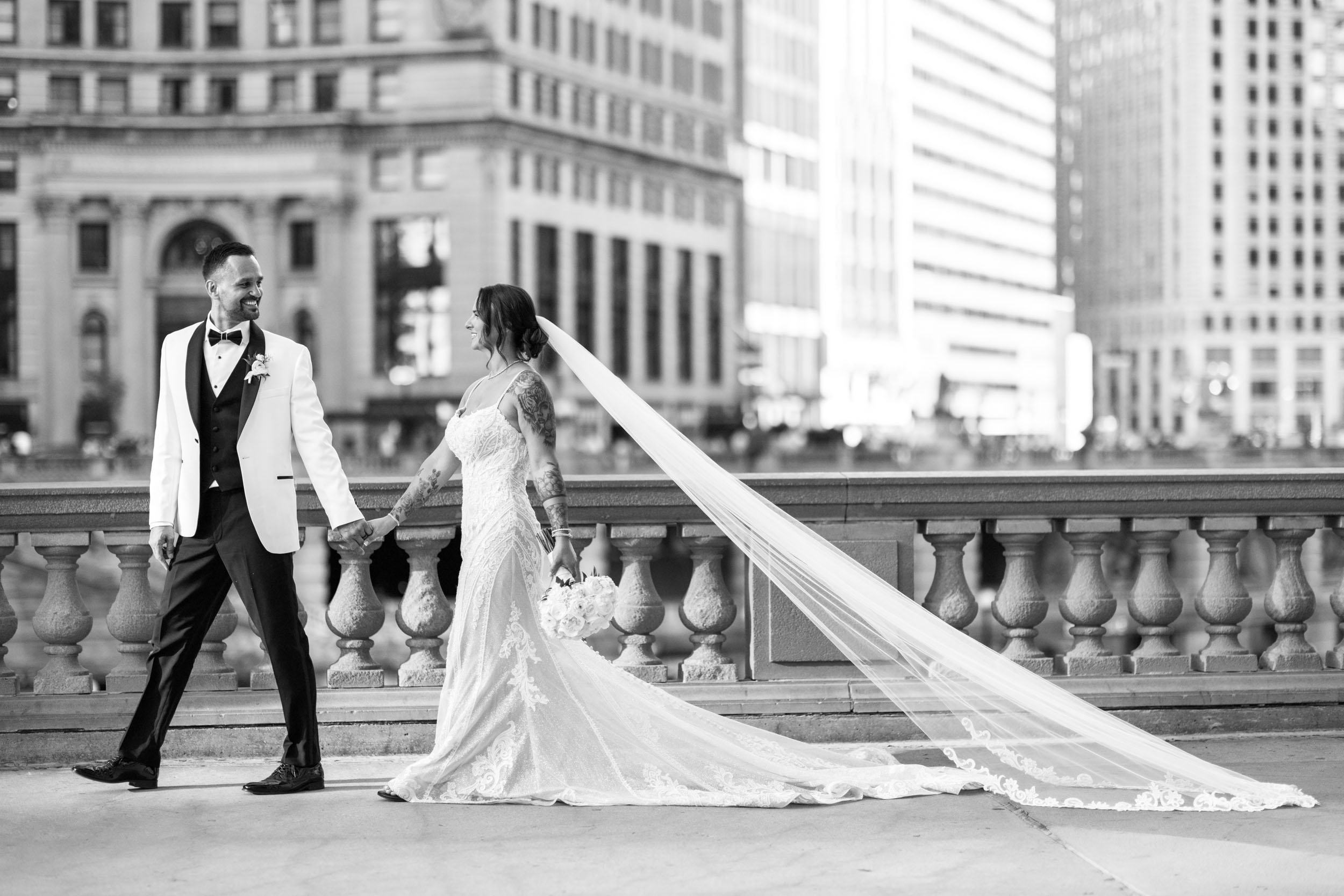 Black and white downtown Chicago wedding portrait of bride and groom with flowing veil